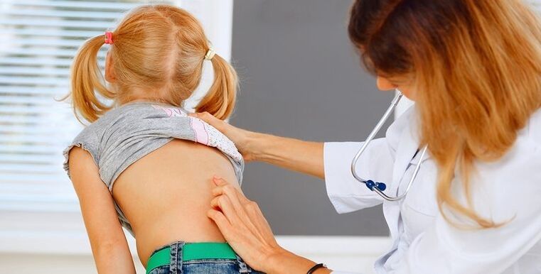 Doctor examining a child's back for lower back pain